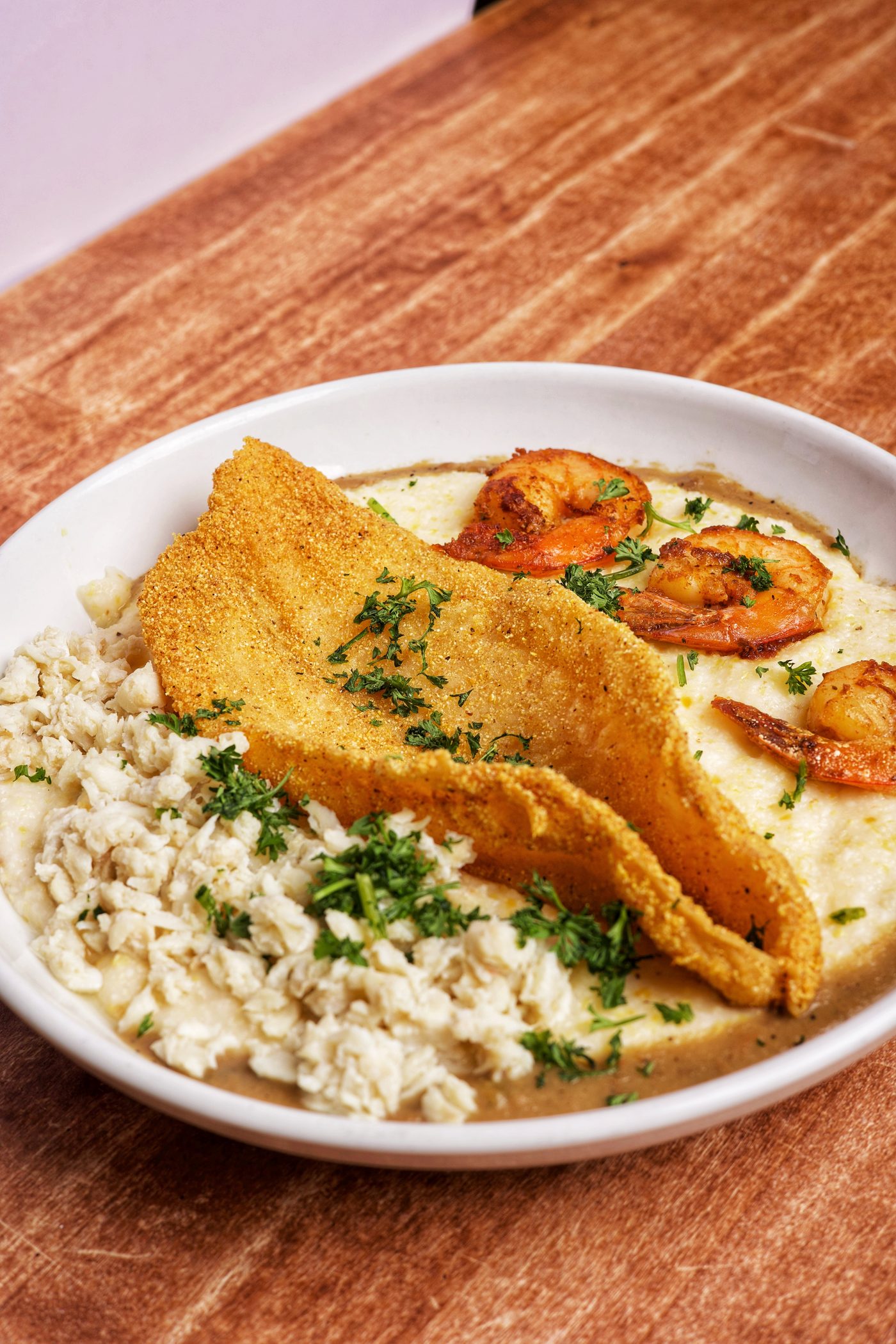 The S.G.G. — cornmeal fried fish, lump crab and shrimp over cheese grits with spicy gumbo gravy